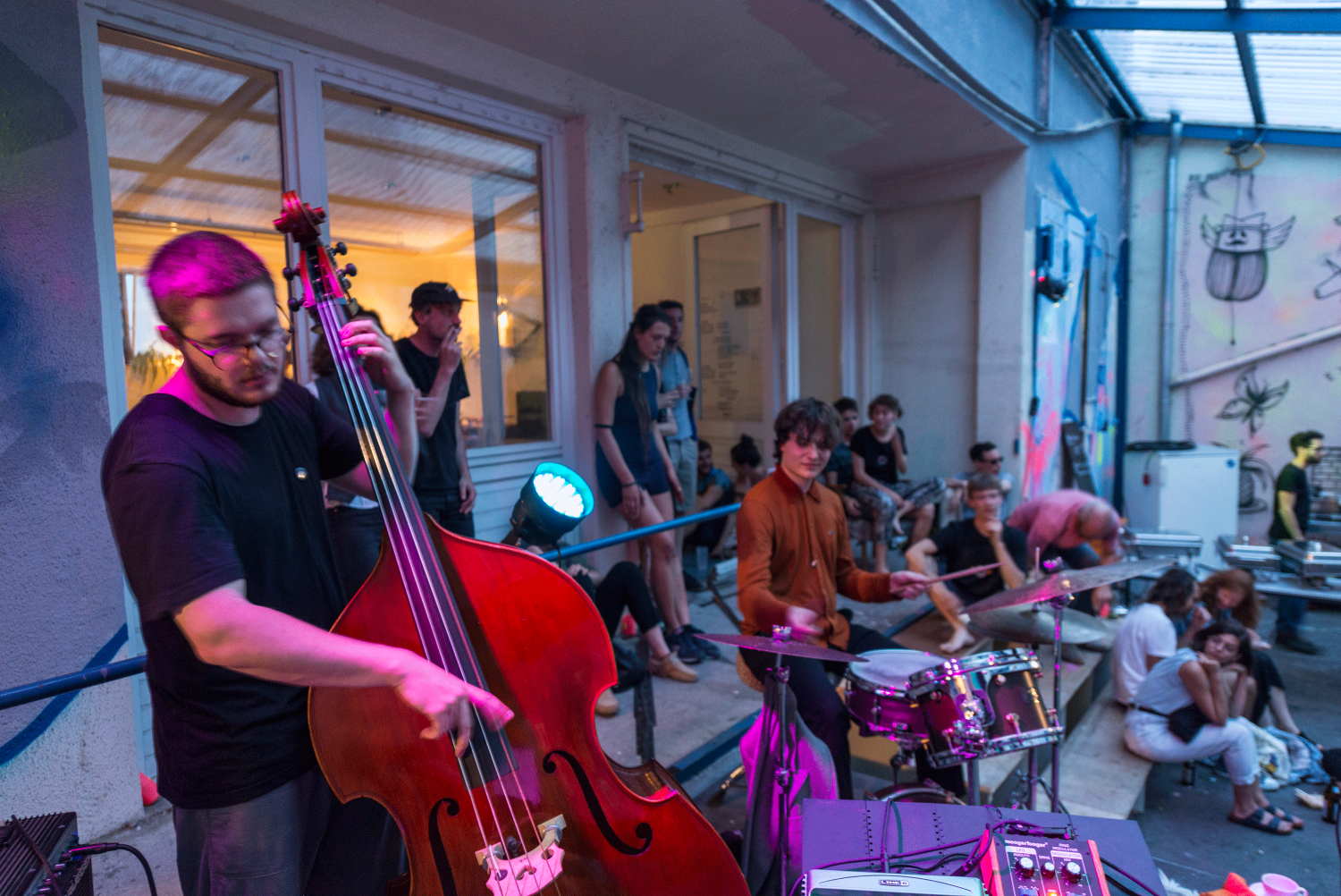 Ein Teil einer Jazzband ist zu sehen, die Musik machen. Ein Musiker sitzt am Schlagzeug der andere spielt Kontrabass.